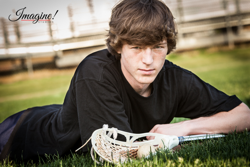 Matthew lying on the lacrosse field for a senior portrait