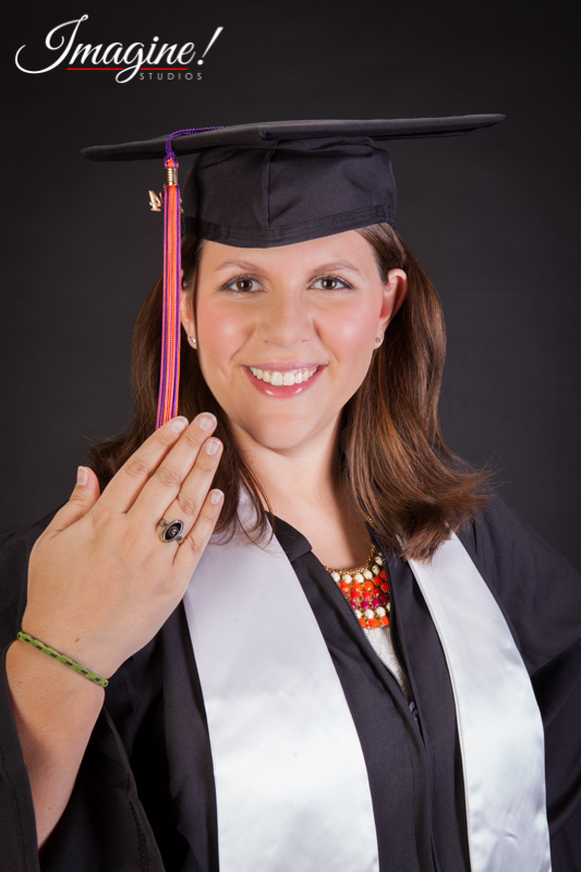 Amethyst dresses in her cap and gown and shows her Clemson University ring
