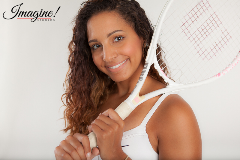 Brianna smiles sweetly with her tennis racquet on her shoulder