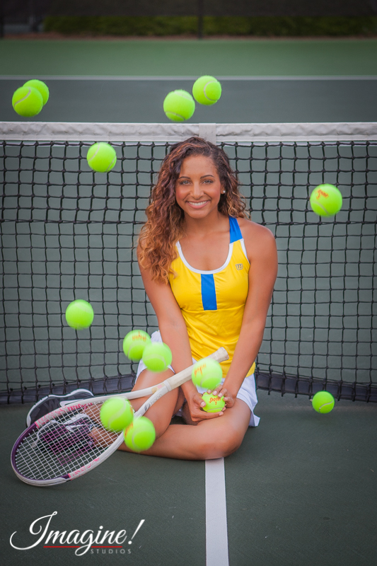 Brianna sits among several bouncing tennis balls