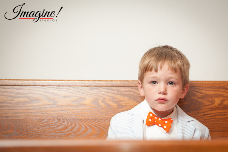 A child waits in a pew for the wedding ceremony to begin
