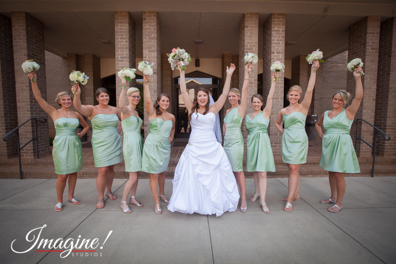Layne and her bridesmaids raise their hands in excitement before the wedding ceremony